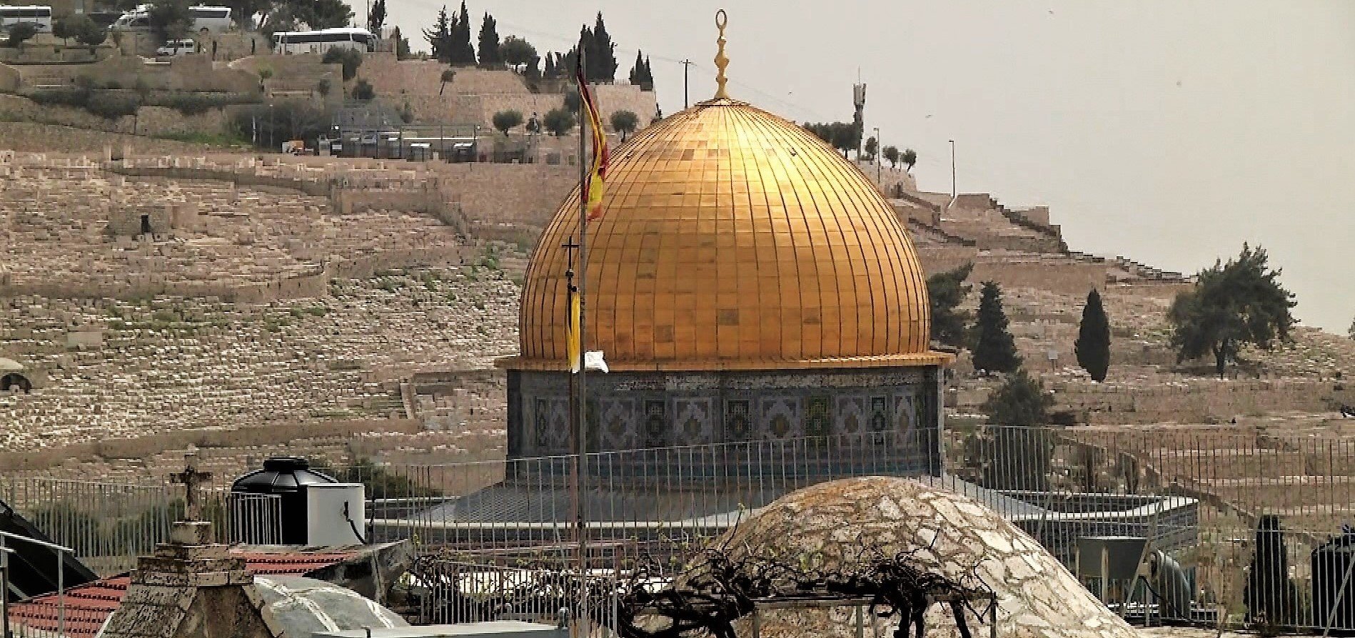 "Leeres Jerusalem": Der Felsendom mit goldener Kuppel in Jerusalem. Im Hintergrund sieht man einen Hügel mit parkenden weißen Bussen. Rechtehinweis: © ZDF und Yaniv Shmueli.