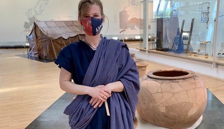 Museumspädagogin Jannike Riekesmann trägt nicht nur ein römisches Gewand, sondern auch den passenden Mundschutz mit Römer-Motiv. Foto: LWL/ J. Mühlenbrock