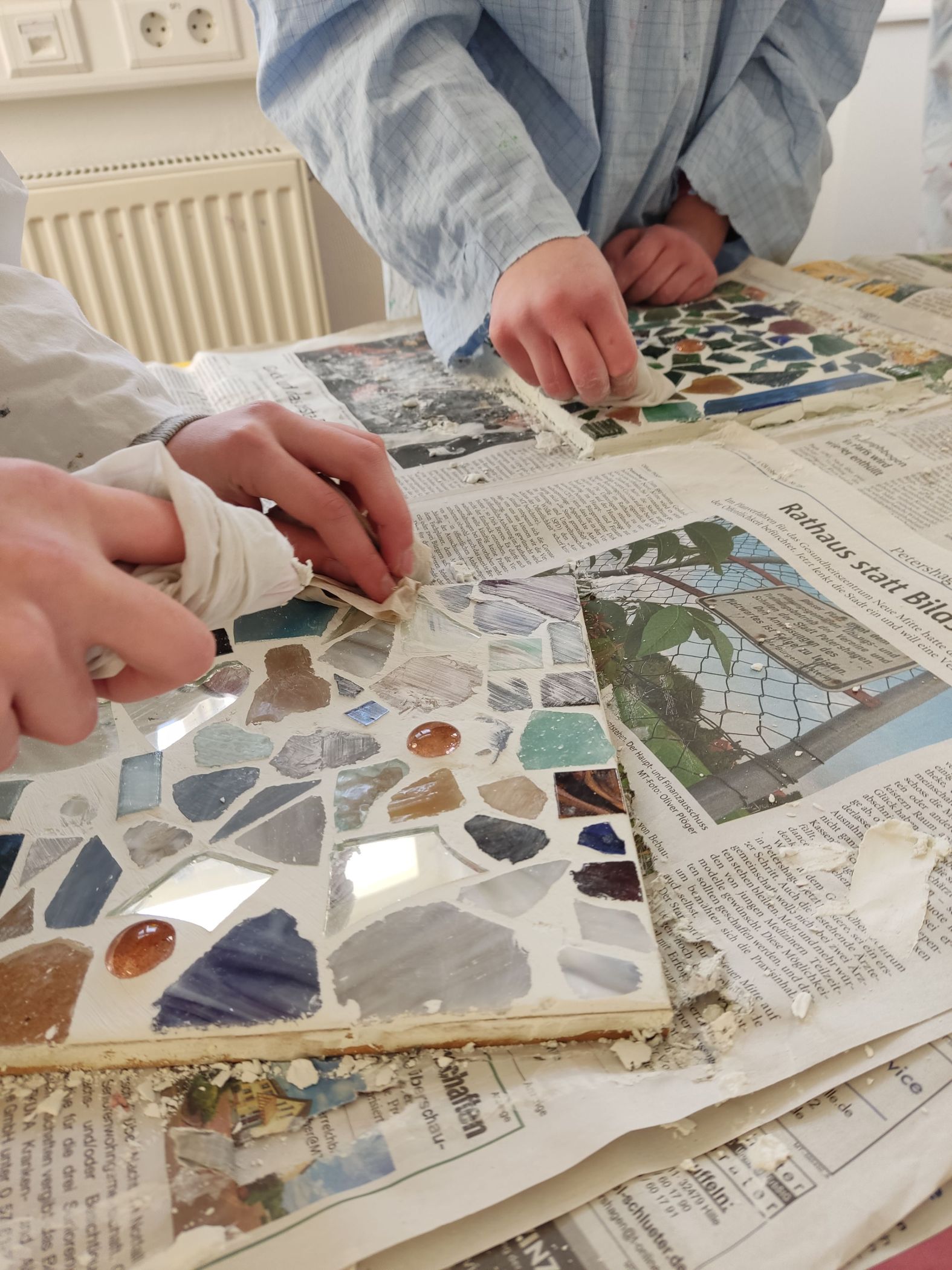 In einer Mosaikwerkstatt der Glashütte Gernheim werden bunte Glassteinchen zu Mustern gelegt / LWL/Dechant